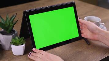 A woman using a tablet with a green screen background, ideal for showcasing mobile apps, digital interactions, or tech-related projects. video