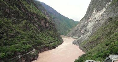 View to the steep valley of Tiger Leaping Gorge with meandering Yangtze River below in the spring of Yunnan, China. video