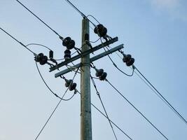 Network of electric cables on power poles with blue sky in the afternoon photo