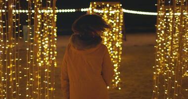 Frau gehen zwischen Weihnachten Dekoration mit Weihnachten Beleuchtung und Girlanden video