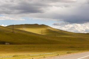 High-voltage power line runs through the hills in Mongolia photo
