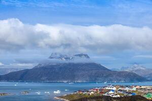 Typical architecture of Greenland capital Nuuk with colored houses located near fjords and icebergs photo