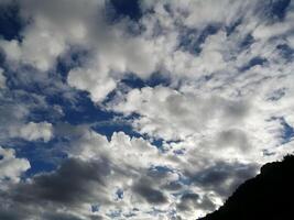 Dramatic Cloudscape With Blue Sky and Silhouetted Mountains photo