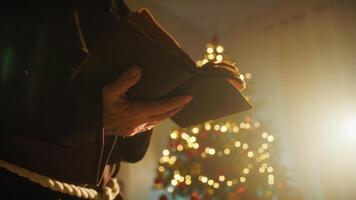 Religious Monk Prays On Christmas Night With Open Gospel In Front Of The Tree video