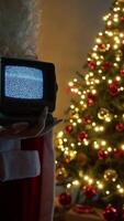 Santa Claus Holds A Vintage Television With Static Signal In Front Of Tree video