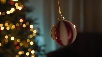 Silhouette Of Swinging Christmas Ball In Front Of Tree In The Room video