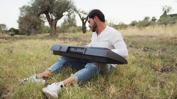 Musician Student Plays The Keyboard Sitting In The Meadow In The Countryside video