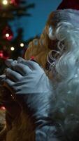 Santa Claus Seated On The Sofa And Drinks Tea Next To The Illuminated Tree video