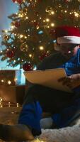 Boy Makes Advent Calendar With Pajamas On Christmas Night Near The Tree video