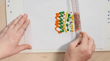 Hands creating colorful abstract patterns with ruler technique on canvas for art and design creativity. video