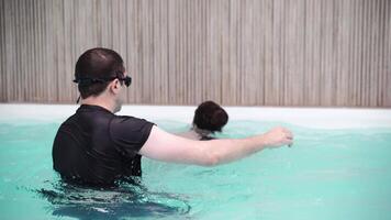 natação lição instrutor guias principiante dentro piscina Habilidades e técnicas. video