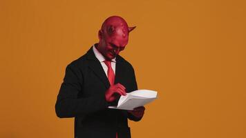 Devil businessman reading and writing on a document video