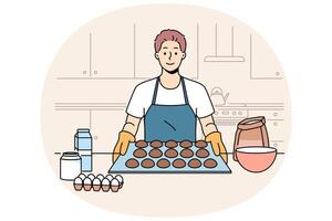 Man baker prepares oatmeal cookies or gingerbread while standing near kitchen table with ingredients vector