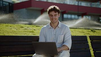 Happy Caucasian man using laptop computer pc programmer smile businessman technology distant work online freelancer positive employee male guy outdoors business gadget coder city internet smiling web video