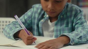 Little boy kid son African American ethnic child concentrated study learn write homework classroom lesson prepare task elementary school education student schoolboy studying drawing writing at desk video