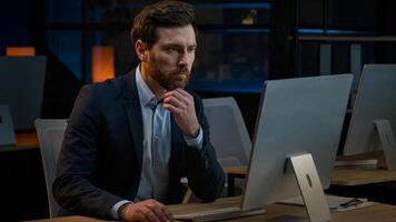 Pensive Caucasian middle-aged man sit at night office thinking deep thought dreaming new project business idea brainstorm solve problem thoughtful male businessman thinking search solution in computer photo