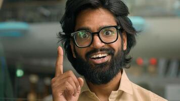 Thoughtful Arabian businessman thinking of business challenge rise finger come up with idea. Pensive Indian bearded man in glasses lost in thoughts think happy with solving problem insight gesture photo
