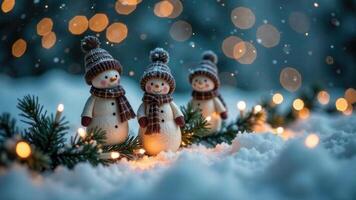 Little snowmen figures in clothes sit in the snow and spruce branches outside, a family theme on New Year's Eve, everning time with snowflakes and bokeh on blurred background, copy space photo