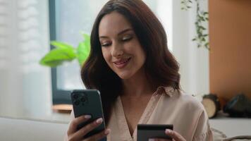 Happy smiling client customer female buyer user Caucasian lady girl shopping with mobile phone bank app pay online buy goods order ecommerce from home woman make internet transaction with credit card photo