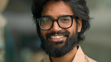 Close up portrait happy Indian bearded 30s businessman in eyeglasses male posing for camera. Handsome Arabian multiethnic man in glasses business executive smiling with toothy smile. Cheerful employer photo