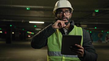 Heavy industry technology engineer Arabian man Indian builder in hard hat electrician architect manufacture worker think pensive ponder problem solution use digital tablet check cyber security system photo