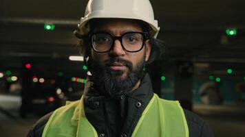 Portrait Indian Arabian bearded man in eyeglasses worker male engineer specialist of manufacture work. Business person in hard hat safety wear uniform and glasses. Contractor mechanic guy in helmet photo