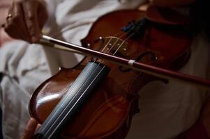 Close-up of a violin being played by a skilled musician indoors photo