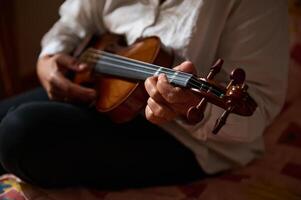 Close-up of musician playing violin with focused hands on strings photo