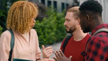 Happy diversity multiracial students diverse multiethnic friends two men and African American woman girl Caucasian guys outdoors university campus in city talking friendly conversation speaking talk photo