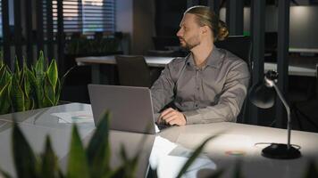 Caucasian businessman at office workplace with laptop working thinking strategy analyzing data business man company employer entrepreneur work computer pensive think idea problem solution difficulty photo