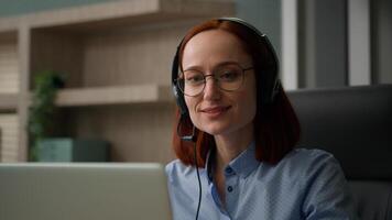 Smiling Caucasian woman with headset talking laptop call girl talk working customer support service operator helpline agent at office calling with computer businesswoman business distance chat photo