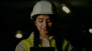 Female inspector supervisor architect developer angry annoyed woman in hardhat inspecting bad engineering work on underground parking use electronic digital tablet computer pad control manufacturing photo