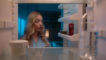 Point of view POV inside refrigerator Caucasian girl hungry woman open fridge at home kitchen look at empty shelves order food products delivery with mobile phone app online service web store shopping photo