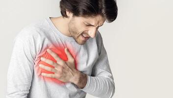 Heart disease concert. Man holds chest, highlighted in red, free space photo