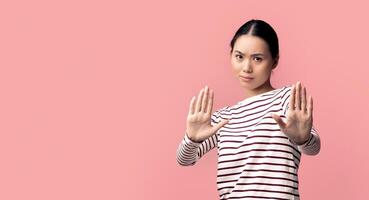 Refusal Concept. Portrait Of Unpleased Asian Lady Showing Stop Gesture With Two Hands, Annoyed Korean Woman Refusing Something Unwanted While Standing Isolated Over Pink Background, Copy Space photo