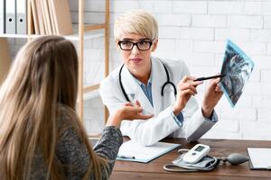 Conversation with patient. Woman dentist explains to patient problem in interior of office photo