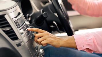 Closeup Of Cheerful African American Lady Changing Radio Station Listening Music In Car, Enjoying Automobile Audio System, Testing Her New Vehicle Pushing Button Turning Volume Up, Profile Side View photo