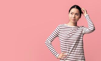 Difficult Choice. Puzzled Asian Lady Touching Head And Looking At Copy Space, Doubtful Confused Young Korean Woman Thinking About Offer While Standing Isolated Over Pink Background, Panorama photo