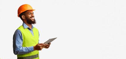 African Construction Foreman Worker Holding Tablet Computer, Smiling Looking Aside Over White Studio Background. Empty Space, Panorama photo