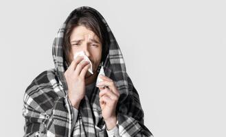 Cold symptoms and nose treatment concept. Man drips nose with spray photo