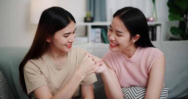 Handheld shot, Asian female couple share good feelings for each other and hold hands with their pinky fingers, indicating a good relationship or sincere promise, Happy times at home video