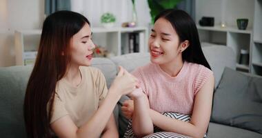 Handheld high angle view shot, Asian female couple share good feelings for each other and hold hands with their pinky fingers, indicating a good relationship or sincere promise, Happy times at home video