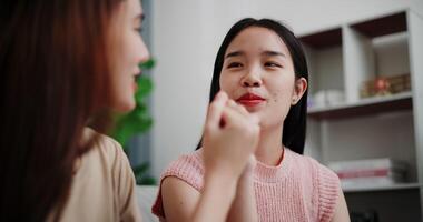 Handheld selective focus shot, Asian female couple share good feelings for each other and hold hands with their pinky fingers, indicating a good relationship or sincere promise, Happy times at home video