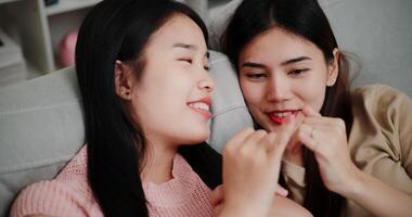 Handheld high angle view shot, Asian female couple share good feelings for each other and hold hands with their pinky fingers, indicating a good relationship or sincere promise, Happy times at home video