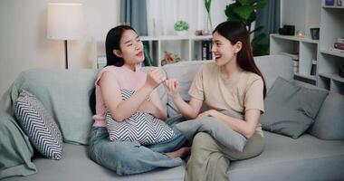 Handheld high angle view shot, Asian female couple share good feelings for each other and hold hands with their pinky fingers, indicating a good relationship or sincere promise, Happy times at home video