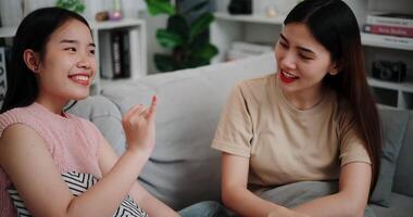 Handheld high angle view shot, Asian female couple share good feelings for each other and hold hands with their pinky fingers, indicating a good relationship or sincere promise, Happy times at home video