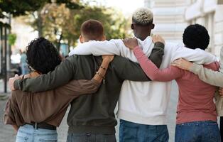 Back view of international group of people making strike on the street, hugging, showing their strong unity, demanding from government saving planet, reducing pollution. Riot, demonstration, strike photo