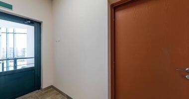 loop seamless rotation in white empty long corridor with red brick walls in interior of modern apartments or office video