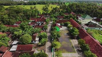 View of the settlement taken from above using a drone. You can see the hills and also the expanse of rice fields behind it. Free Videos