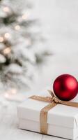 Festive red ornament on a gift box during the holiday season with blurred lights photo